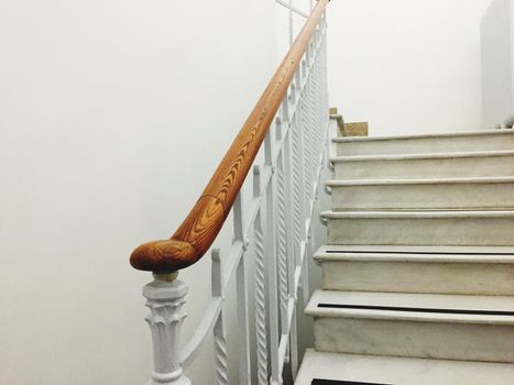 Ancient white staircase with elegant wooden handrail