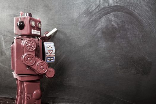 vintage robot writes on black board 