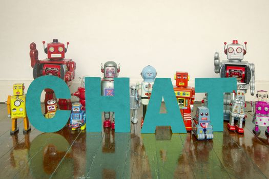 retro robots on a wooden floor with the word CHAT  with reflection