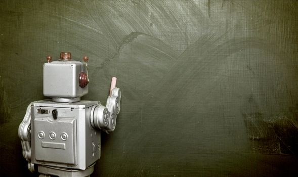 vintage robot writes on black board 