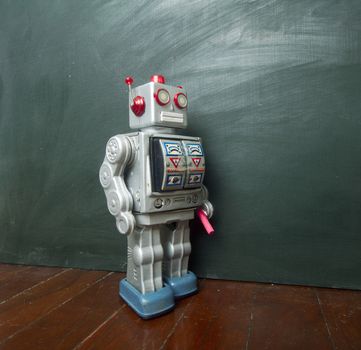 vintage robot writes on black board 