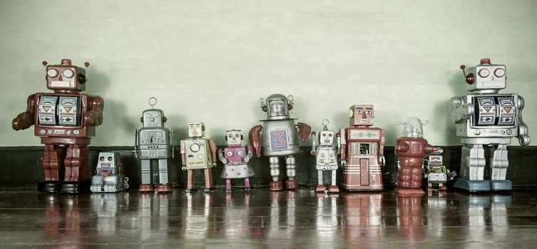 a line of retro robot toys on a wooden floor