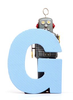 capital letter G  held by vintage robot toys 