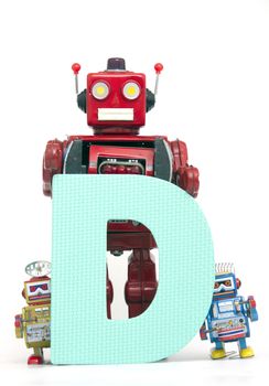 capital letter  D held by vintage robot toys 