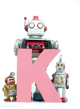 capital letter K  held by vintage robot toys 