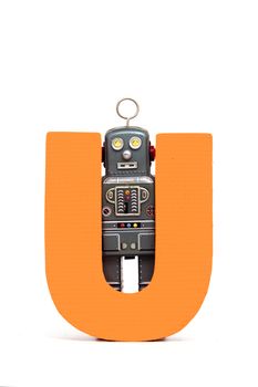 capital letter U held by vintage robot toys 