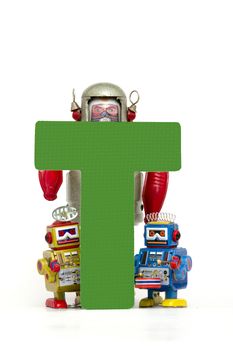 capital letter T held by vintage robot toys 