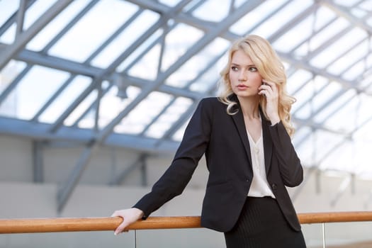 Business woman talking on phone in business center