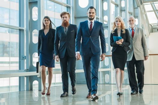 Business team walking in modern glass office building
