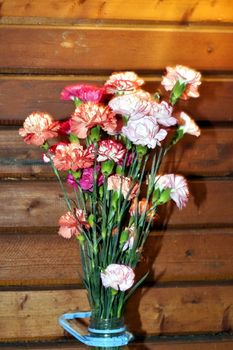 bouquet of colorful carnations on a simple wooden background