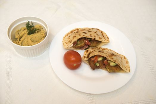popular Israeli dish - falafel in a plate on a white tablecloth.