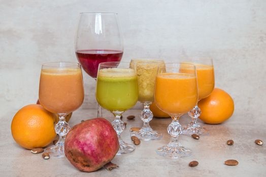 Six fresh juice mix vegetables and fruit, healthy drinks on grey table.