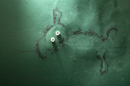 Fun dog resting made from green paper, water and ink