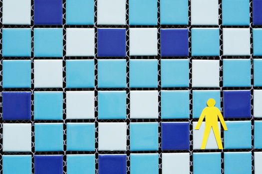 Alone man figure made from yellow paper on blue cube background