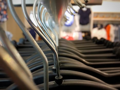 Many hangers on a clothes rack in a fashion store
