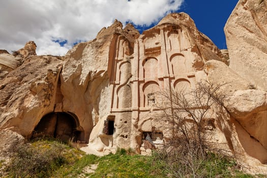 Ancient temple in stone cliffs and cave houses near Goreme, Turkey