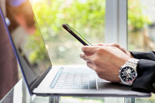 Business man using smart phone and working on laptop, Close up of hands of business man, Business concept.