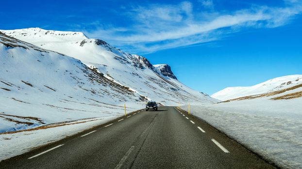 A long straight road and cars in winter. 