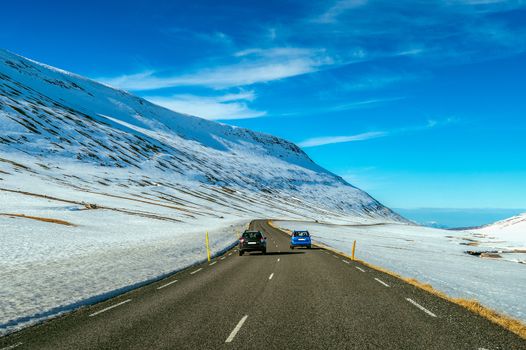 A long straight road and cars in winter. 