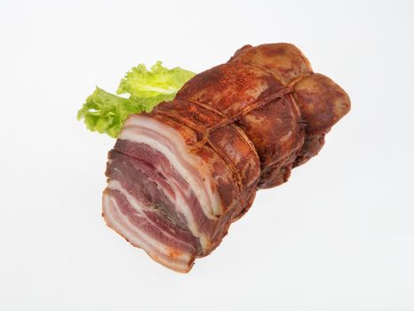 Piece of bacon with greenery on an isolated studio background