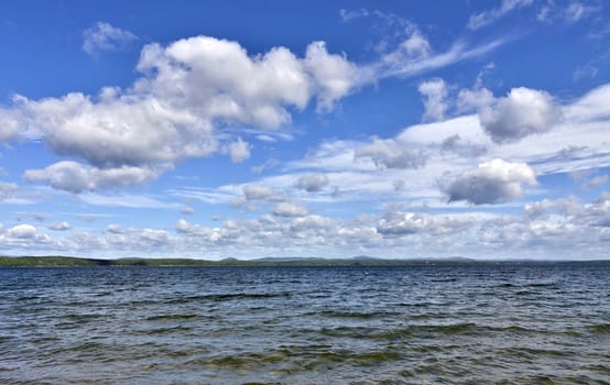 view of the blue sky over the lake with beautiful feathery and cumulonimbus clouds on a Sunny day, the southern Urals, lake Uvildy