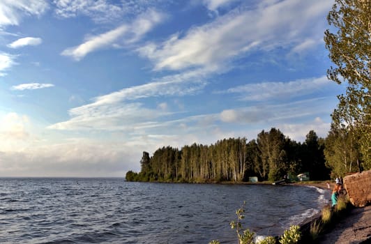 view of the blue sky over the lake with beautiful feathery and cumulonimbus clouds on a Sunny day, the southern Urals, lake Uvildy