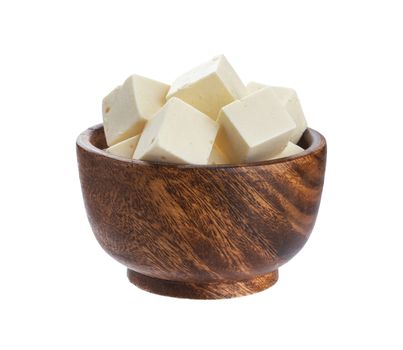 Greek feta cubes in wooden bowl. Diced soft cheese isolated on white background with clipping path