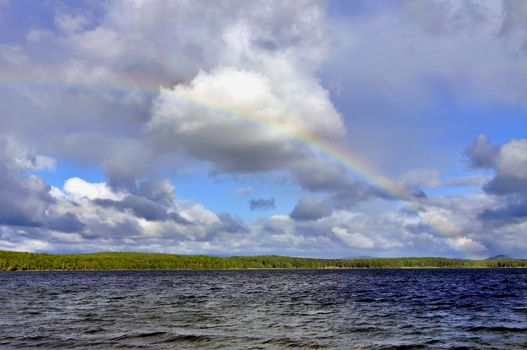 beautiful morning rainbow over the troubled lake