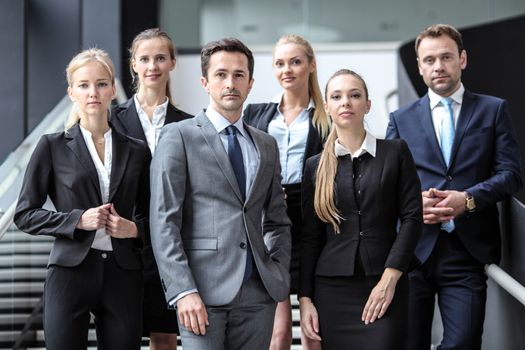 Portrait of successful business people team standing together in modern office building