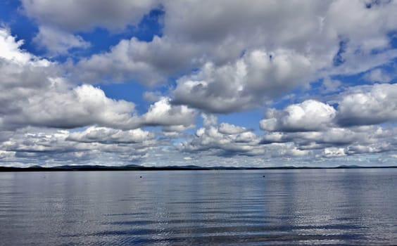 view of the blue sky over the lake with beautiful feathery and cumulonimbus clouds on a Sunny day, the southern Urals, lake Uvildy