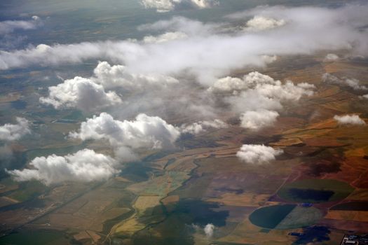 Patchwork farmland and clouds formations seen from the plane