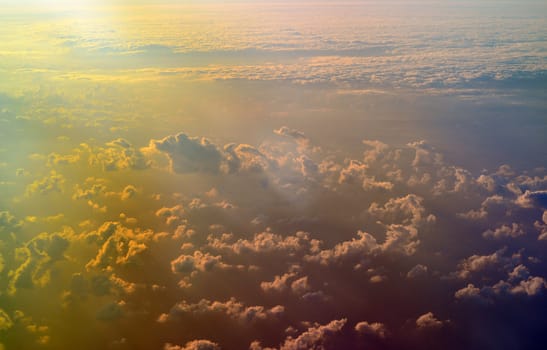 Sky, cloud formations and sun rays seen from the plane