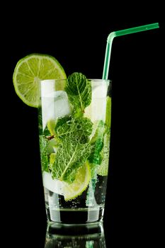 Mojito cocktail with lime, mint and ice on black background 