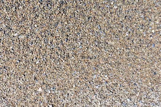 texture of wet sand with small stones on the lake