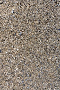 texture of wet sand with small stones on the lake