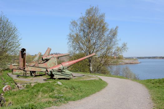 Four rusty green cannons from the Russian period point out over the water from Suomenlinna sea fortress