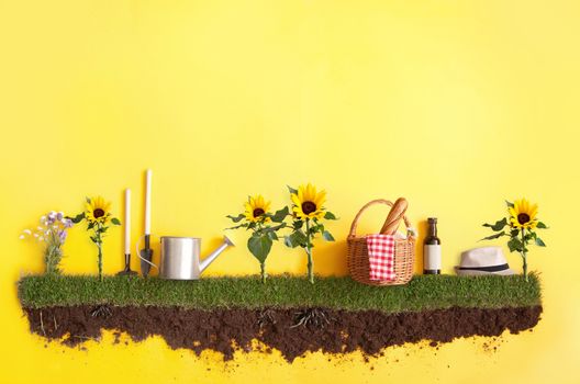 Summer picnic basket on grass patch with sunflowers