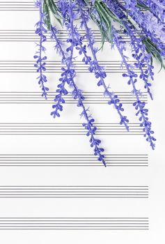 Blue lavender flowers on empty sheet music paper. Sounds of nature or romantic music concept.