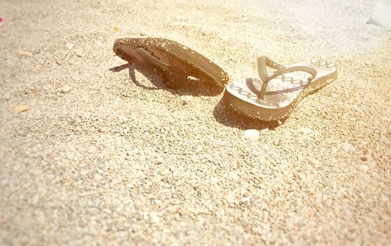 A pair of flip-flops on a stony beach