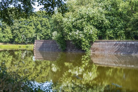Bastion Oranje the old fortified town of Naarden with reflection of flowers in the water, North Holland, Netherlands, Dutch fortress in water surrounded Naarden Vesting