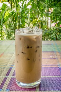 iced coffee with milk on table with nature background