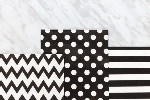 Black and white paper with simple design, on marble background.