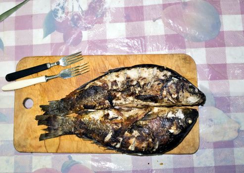 grilled fish with a Golden crust and laid out on a wooden Board