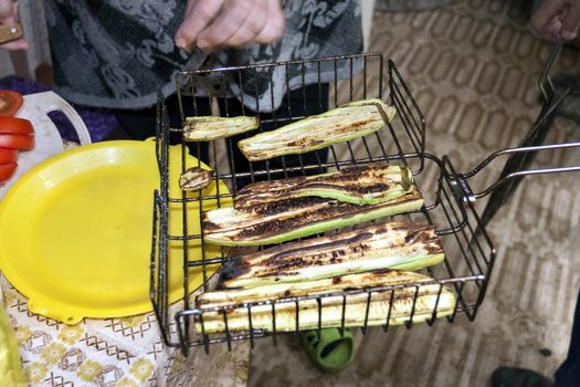 grilled zucchini spread on a plate, visible hands of the cook, cooking for the picnic
