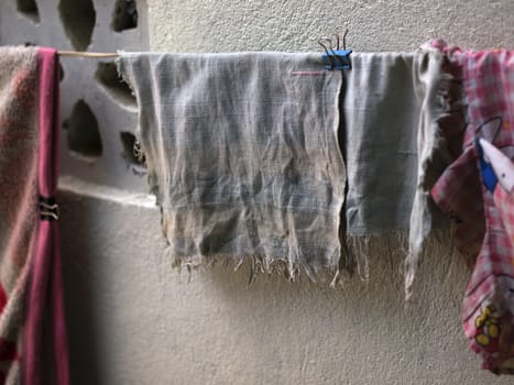 COLOR PHOTO OF OLD AND FADED HANDKERCHIEF DRYING OUTSIDE