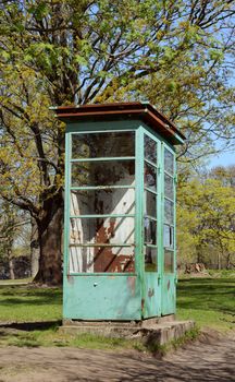 Weathered and rusted disused phone booth with peeling pale green paint on Suomenlinna island, Finland