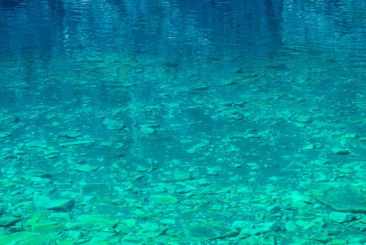 transparent water of a mountain lake, a view of the rocky bottom