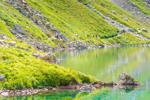 Slope of the mountain and part of the mountain lake close up