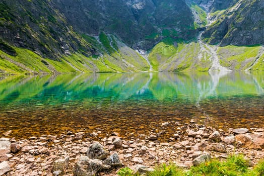 clean mountain cold lake Czarny Staw close-up on a sunny day