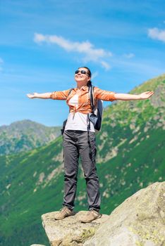 vertical portrait in full length of a tourist with a backpack on a background of high mountains